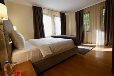 a bedroom with a bed and a large window at Dolomiti Apartments in Bansko