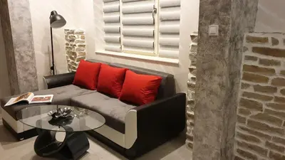 a living room with a couch with red pillows and a table at Apartment Unique in Plovdiv