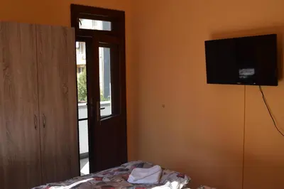 a bedroom with a flat screen tv on the wall at Vesi's Rooms in Plovdiv