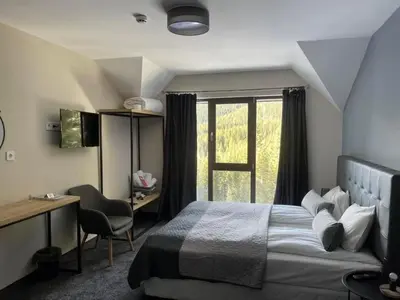 a bedroom with a bed and a desk and a window at Villa Ivan & Petar in Semkovo