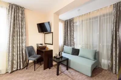 a hotel room with a couch and a table and a chair at Villa Ivan & Petar in Semkovo
