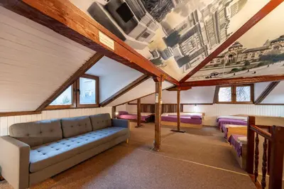 a attic room with a couch and some beds at Central House for up to 16 Guests Entire Place in Sofia