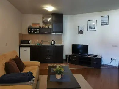 a living room with a couch and a table at Sunny studio apartment - few steps from Gondola in Bansko