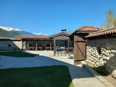 a stone house with a patio and a stone wall at Къща за гости 