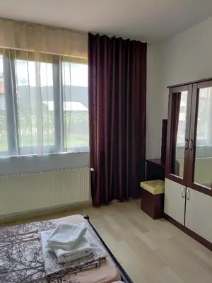 a room with a bed and a large window at Къща за гости 