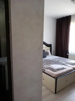 a room with a bed with a wall next to it at Къща за гости 