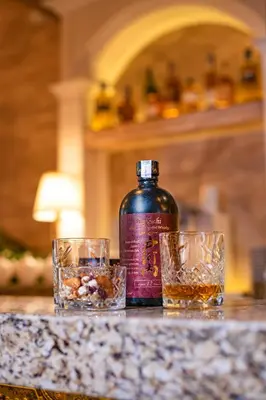 a bottle of whiskey and two glasses on a counter at Hotel Antique - free private parking in Plovdiv
