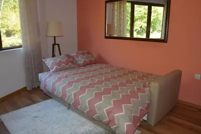 a bedroom with a bed and a mirror on the wall at Rebus Apartments in Sandanski
