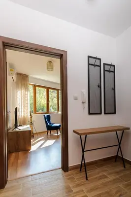 a living room with a table and a mirror at Rebus Apartments in Sandanski