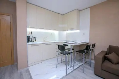 a kitchen with a table and chairs and a couch at ГеВе Апартаменти in Sandanski