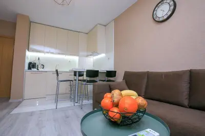 a living room with a bowl of fruit on a table at ГеВе Апартаменти in Sandanski