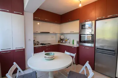 a small kitchen with a white table and chairs at Апартамент за гости Римски терми in Kyustendil
