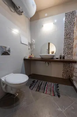 a bathroom with a toilet and a sink and a mirror at Апартаменти Ковачева in Bansko