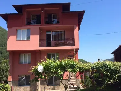 a red building with trees in front of it at Vasilevi House in Devin