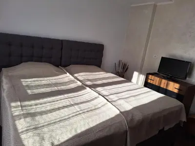 a bed with a striped blanket on it in a bedroom at Vasilevi House in Devin