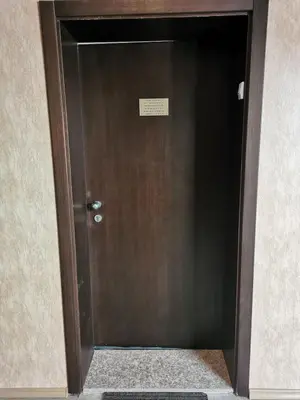 a brown door with a sign on it at Апартаменти Ковачева-2 in Bansko
