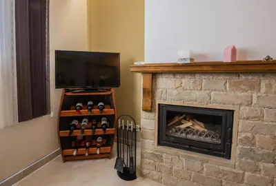 a living room with a fireplace with a flat screen tv at Апартаменти Ковачева-2 in Bansko