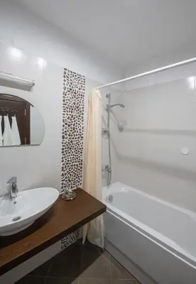 a bathroom with a tub and a sink and a bath tubermottermott at Апартаменти Ковачева-2 in Bansko