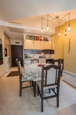 a dining room with a table and chairs and a kitchen at Апартаменти Ковачева-2 in Bansko