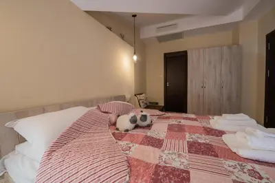 a stuffed animal is laying on a bed at Апартаменти Ковачева-2 in Bansko