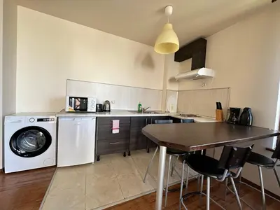 a kitchen with a washing machine and a table at Neon Luxury apartments next to the Gondola in Bansko