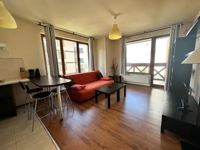 a living room with a red couch and a table at Neon Luxury apartments next to the Gondola in Bansko