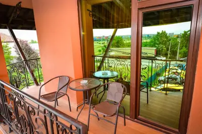 a balcony with two chairs and a table on it at Guest house VRAZHDEBNA in Sofia
