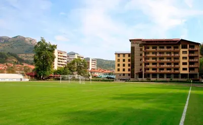 a large green field in front of a building at Olymp Hotel in Teteven