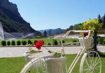 a white bike parked next to two flower pots at Olymp Hotel in Teteven