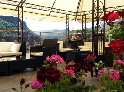 a room with couches and flowers and a view at Olymp Hotel in Teteven