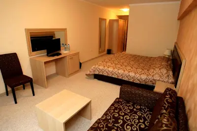 a hotel room with a bed and a television at Olymp Hotel in Teteven