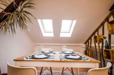 a dining room table with chairs and a skylight at Off Vitosha Blvd Designer Apart in Sofia