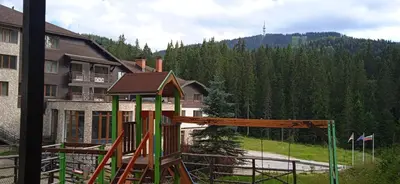 a playground in front of a house with a building at Спа,ски апартамент Дайли, Стрийм Ризорт Пампорово in Pamporovo