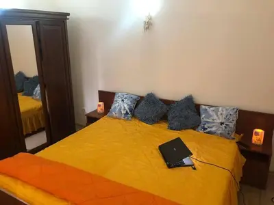 a bedroom with a yellow bed with a laptop on it at Спа,ски апартамент Дайли, Стрийм Ризорт Пампорово in Pamporovo