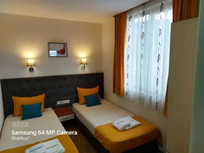 a small room with two beds and a window at Sharkov Family Hotel in Ognyanovo