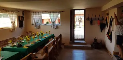 a dining room with a long table with flowers on it at Къщи за гости Ореха in Samokov
