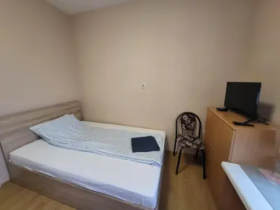 a small bedroom with a bed and a desk with a computer at East Gate Guest Rooms in Plovdiv