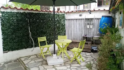 a patio with a table and chairs and an umbrella at East Gate Guest Rooms in Plovdiv
