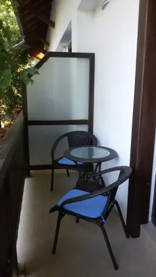 a table and two chairs on a balcony at Family Hotel Pchelina in Rilski Manastir