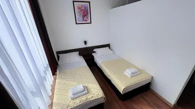 two twin beds in a room with a window at ASPEN GOLF RESORT Ski & Spa RELAX APARTMENT in Bansko