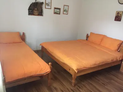 two beds in a room with orange sheets at Къща за гости Спасителна in Brezhani