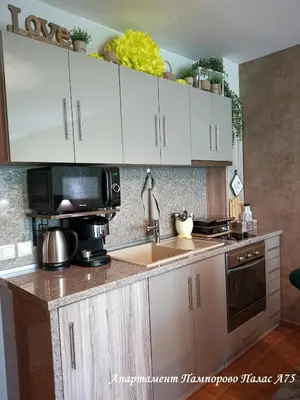 a kitchen with white cabinets and a sink and a microwave at Apartment Pamporovo Palaсe A75 in Pamporovo