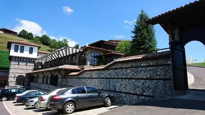 a car parked in front of a stone wall at Panorama Family Hotel in Zlatograd