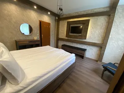 a bedroom with a large white bed and a chair at Deluxe 206 in Borovets
