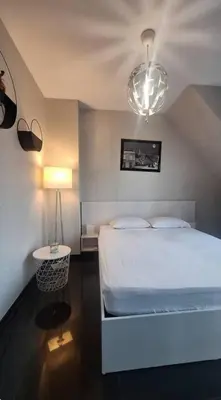 a bedroom with a white bed and a lamp at AHINORA in Plovdiv