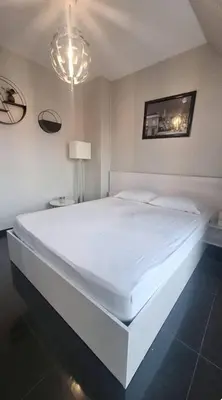 a large white bed in a bedroom with a chandelier at AHINORA in Plovdiv