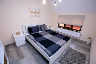 a bedroom with a black and white bed and a window at Babylon Park Apartment in Sandanski