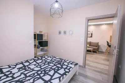 a bedroom with a black and white bed and a mirror at Babylon Park Apartment in Sandanski
