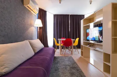 a hotel room with a couch and a table with chairs at The Perfect One-Bedroom Maisonette in Plovdiv by Flat Mаnager in Plovdiv