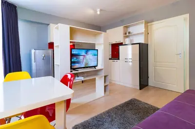 a living room with a white table and a kitchen at The Perfect One-Bedroom Maisonette in Plovdiv by Flat Mаnager in Plovdiv